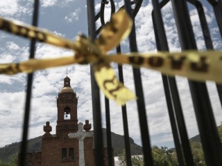 Cảnh sát phong tỏa hiện trường vụ án xung quanh nhà thờ Cerocahui, Mexico, ngày 22 tháng 6 năm 2022, nơi hai linh mục Dòng Tên lớn tuổi bị giết hai bên trong nhà thờ. Đã hai tháng kể từ khi hai Linh mục Dòng Tên bị giết hại tại cộng đồng vùng núi hẻo lánh ở miền bắc Mexico này và kẻ tình nghi là kẻ giết người vẫn đang tiếp tục dửng dưng trước pháp luật (Ảnh: Christian Chavez / AP)