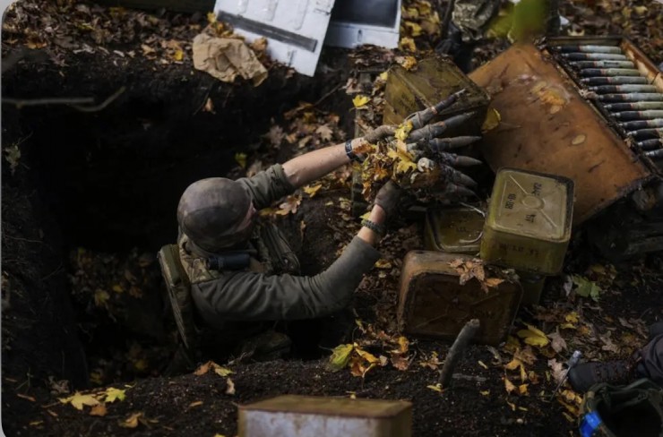Một công nhân phá mìn bảo vệ lãnh thổ Ukraine lấy đạn dược của Nga bị bỏ lại khi nhóm của anh rà phá bom mìn gần làng Hrakove, Ukraine, thứ Năm, ngày 13 tháng 10 năm 2022 (Ảnh: AP Photo / Francisco Seco)