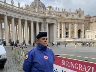 Một tình nguyện viên của Hội Chữ thập đỏ Ý đứng ở Quảng trường Thánh Phêrô vào ngày 10 tháng 11 năm 2022, sẵn sàng chào đón bất kỳ người nào muốn khám sức khỏe hoặc xét nghiệm máu miễn phí do các bác sĩ, y tá và sinh viên y khoa tình nguyện cung cấp như một phần của việc cử hành Ngày Thế giới Người nghèo (Ảnh: CNS / Cindy Wooden)