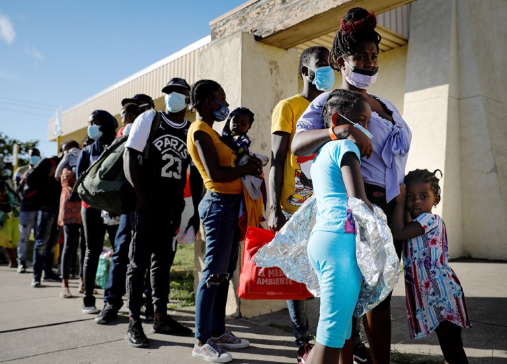 Những người di cư được Cơ quan Hải quan và Bảo vệ Biên giới Hoa Kỳ ở Del Rio, Texas trả tự do, đang xếp hàng chờ lên xe buýt đến Houston vào ngày 24 tháng 9 năm 2021. (Ảnh: Marco Bello / Reuters, qua CNS)