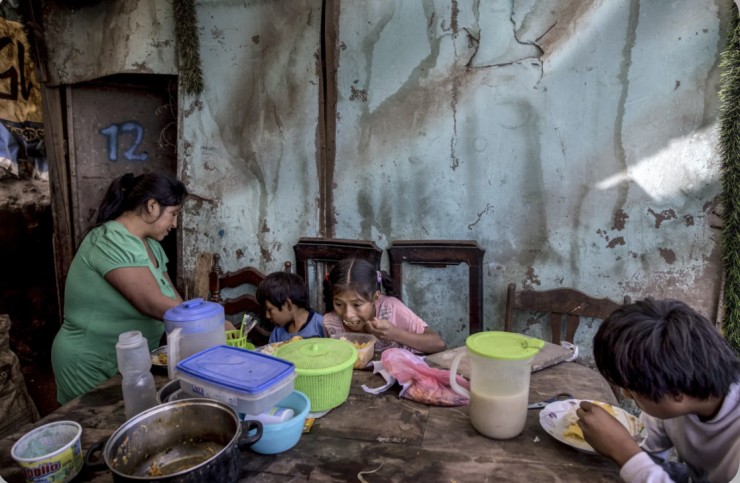 Ba người con của Consuelo Pascacio; Estiben 4 tuổi, Estefany, 11 tuổi và Javier, 14 tuổi, đang ngấu nghiến món cơm gà hầm mà chị nhận  được từ một “bếp ăn cộng đồng”, tại nhà của họ ở khu phố Nueva Esperanza, Lima, Peru, thứ Hai, ngày 8 tháng 6 năm 2020 (Ảnh: Rodrigo Abd/AP)