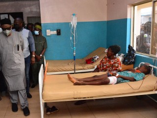 Các quan chức chính phủ đi ngang qua các nạn nhân bị thương trên giường bệnh đang được điều trị vết thương sau vụ tấn công của các tay súng tại Nhà thờ Công giáo Thánh Phanxicô Xaviê  ở Owo, tây nam Nigeria, vào ngày 5 tháng 6 năm 2022 (Ảnh: AFP/ Getty Images)