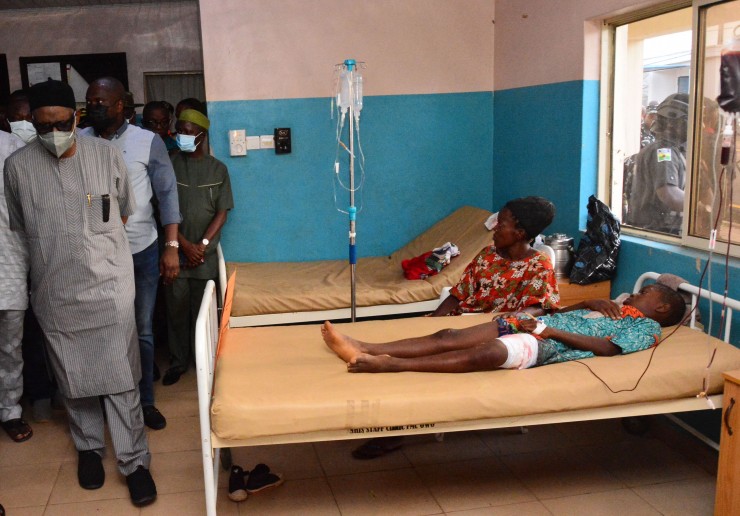 Các quan chức chính phủ đi ngang qua các nạn nhân bị thương trên giường bệnh đang được điều trị vết thương sau vụ tấn công của các tay súng tại Nhà thờ Công giáo Thánh Phanxicô Xaviê  ở Owo, tây nam Nigeria, vào ngày 5 tháng 6 năm 2022 (Ảnh: AFP/ Getty Images)