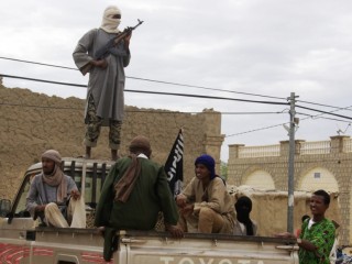 Trong bức ảnh được chụp vào ngày 31 tháng 8 năm 2012, các chiến binh thuộc nhóm Hồi giáo Ansar Dine đứng gác ở Timbuktu, Mali, khi họ chuẩn bị đả kích công khai một thành viên của Cảnh sát Hồi giáo bị kết tội ngoại tình.