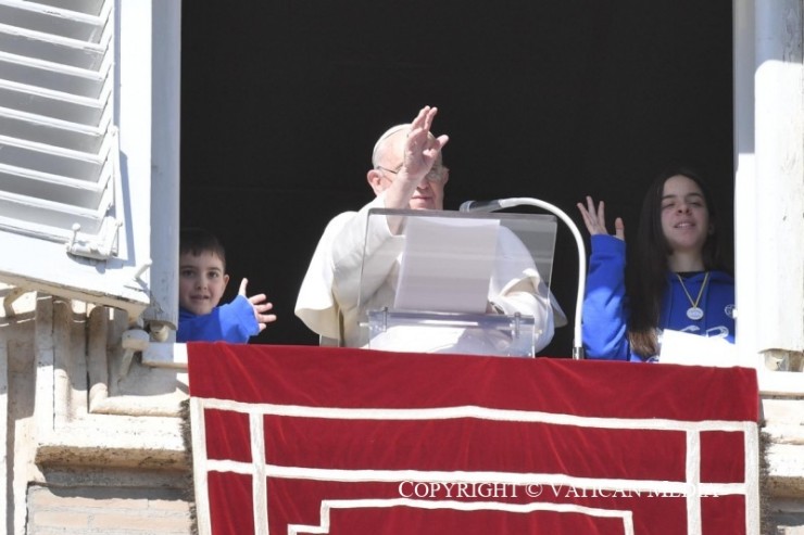 Một bé trai và một bé gái mặc áo nỉ màu xanh cùng với Đức Thánh Cha Phanxicô đọc to bức thư chia sẻ những nỗ lực của họ tại cửa sổ của Điện Tông Tòa như một phần của “Đoàn lữ hành vì hòa bình” của phong trào Công giáo Tiến hành (Ảnh: Truyền thông Vatican)