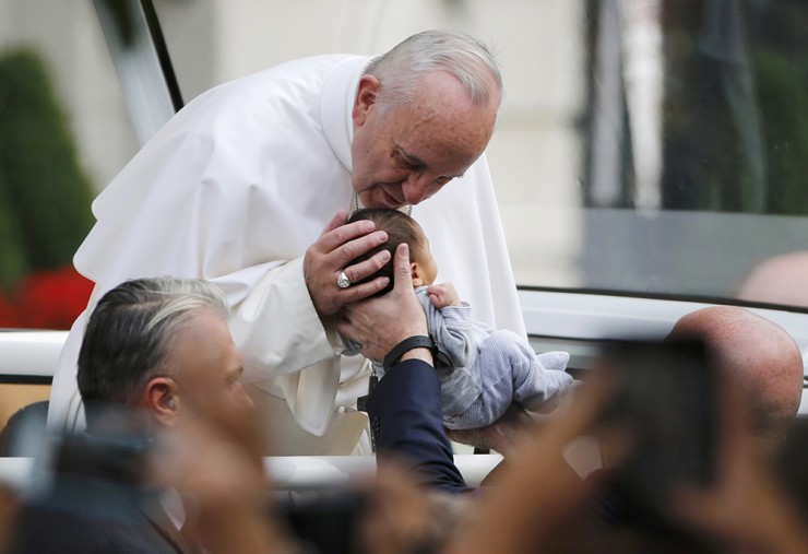 Đức Thánh Cha Phanxicô dừng lại để hôn một đứa trẻ khi ngài đi trên chiếc xe popemobile đến Hội trường Độc lập, ngày 26 tháng 9 năm 2015, ở Philadelphia (Ảnh: CNS/Reuters/Jim Bourg)