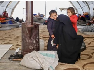 Một phụ nữ Syria và các con sưởi ấm bên bếp lò tại một nơi trú ẩn khẩn cấp ở trung tâm thành phố Maarat Misrin, thuộc khu vực do quân nổi dậy chiếm giữ ở phía bắc của tỉnh Idlib, tây bắc, ngày 7 tháng 2 năm 2023, một ngày sau trận động đất chết người tấn công Syria và Thổ Nhĩ Kỳ (Ảnh: ABDULAZIZ KETAZ/AFP via Getty Images)