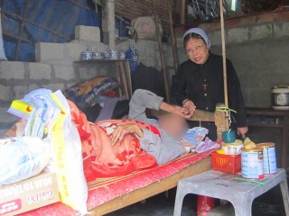 Nữ tu Lucia Nguyễn Thị Ngô FMI phát cơm, mì gói và sữa cho một bệnh nhân (được che mặt để bảo vệ danh tính) vào ngày 12 tháng 11 năm 2022, tại huyện Phú Lộc, Việt Nam (Ảnh: GSR/Joachim Phạm)