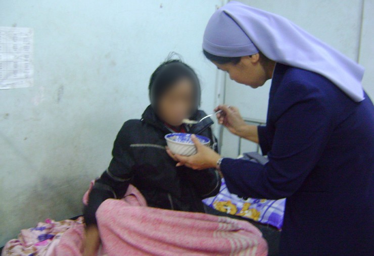 Nữ tu Agnes Trương Ngọc Lan FMI cho một bệnh nhân bị bệnh nặng ăn (được che mặt để bảo vệ danh tính) vào ngày 3 tháng 12 năm 2022, tại Huế (Ảnh: GSR/Joachim Phạm)