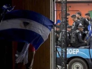 Một người đàn ông cầm quốc kỳ Nicaragua lộn ngược trong Thánh lễ tại nhà thờ San Miguel ở Masaya, Nicaragua, ngày 28 tháng 8 năm 2019. Các nhóm ủng hộ chính phủ cùng với cảnh sát Nicaragua bao vây người Công giáo trong một Thánh lễ đòi tự do cho "các tù nhân chính trị" (Ảnh: EFE/Jorge Torres/MaxPPP)