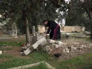 Đức Cha Hosam Naoum, một Giám mục Anh giáo người Palestine, tại một trong 30 ngôi mộ mà những kẻ phá hoại đã mạo phạm tại Nghĩa trang Tin lành lịch sử trên Núi Zion tại Giêrusalem, ngày 4 tháng 1 năm 2023 (Ảnh: MAHMOUD ILLEAN/AP)