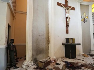 Một sĩ quan cảnh sát đứng gác bên trong Nhà thờ Công giáo Thánh Phanxicô, một ngày sau vụ tấn công nhắm vào các tín hữu ở Owo, Nigeria, thứ Hai, ngày 6 tháng 6 năm 2022. Các tay súng đã giết hại 50 người tại một nhà thờ Công giáo ở tây nam Nigeria đã nổ súng vào các tín hữu cả bên trong lẫn bên ngoài tòa nhà trong một vụ tấn công phối hợp trước khi tẩu thoát khỏi hiện trường (Ảnh: AP/Sunday Alamba)