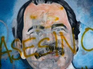 Từ tiếng Tây Ban Nha có nghĩa là "tên sát thủ" được vẽ trên bức tranh tường ở Managua, Nicaragua, của Tổng thống Daniel Ortega vào năm 2018 (Ảnh: Esteban Felix/Associated Press)