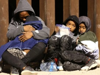 Những người nhập cư xin tị nạn ở Hoa Kỳ chờ đợi khi họ được các nhân viên Biên phòng Hoa Kỳ giải quyết vào sáng sớm sau khi vượt biên vào Arizona từ Mexico vào ngày 10 tháng 5 năm 2023 tại Yuma, Arizona (Ảnh: Mario Tama / Getty Images)