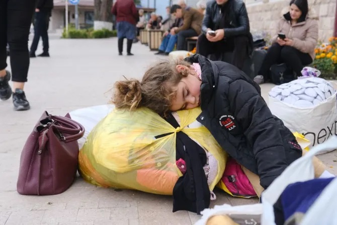 Một bé gái ngủ trên đường phố ở thị trấn Stepanakert vào ngày 25 tháng 9 năm 2023. Những người tị nạn gốc Armenia bắt đầu rời Nagorno-Karabakh vào ngày 24 tháng 9 năm 2023, lần đầu tiên kể từ khi Azerbaijan phát động một cuộc tấn công nhằm giành quyền kiểm soát khu vực lãnh thổ ly khai và có thể chấm dứt cuộc xung đột kéo dài ba thập kỷ (Ảnh: HASMIK KHACHATRYAN/AFP qua Getty Images)