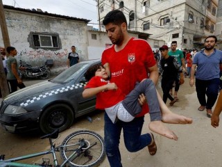 Một người đàn ông bế một đứa trẻ tại địa điểm xảy ra cuộc không kích của Israel vào một ngôi nhà ở Khan Younis, phía nam Dải Gaza, ngày 27 tháng 10 năm 2023, khi xung đột giữa Israel và nhóm Hồi giáo Palestine Hamas vẫn tiếp tục (Ảnh: OSV News/Mohammed Salem, Reuters)