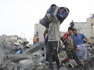 Người dân Palestine nhặt nhạnh đồ đạc của họ sau cuộc không kích của Israel ở Rafah, Dải Gaza, vào thứ Tư, ngày 22 tháng 11 (Ảnh: Hatem Ali/AP)