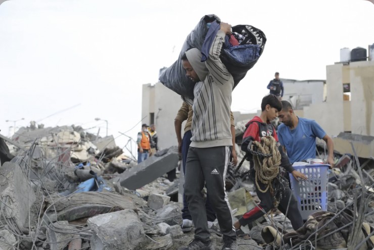 Người dân Palestine nhặt nhạnh đồ đạc của họ sau cuộc không kích của Israel ở Rafah, Dải Gaza, vào thứ Tư, ngày 22 tháng 11 (Ảnh: Hatem Ali/AP)