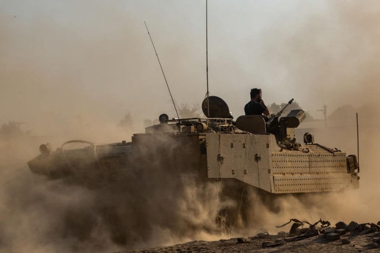 Một tàu sân bay bọc thép (APC) tung bụi mù khi di chuyển qua cánh đồng gần biên giới Gaza vào ngày 13 tháng 11 năm 2023 ở miền Nam Israel (Ảnh: Alexi J. Rosenfeld/Getty Images)