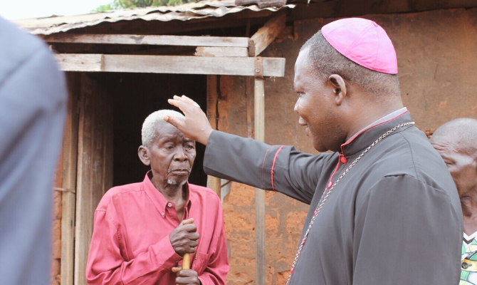 Đức Tổng Giám mục Dieudonné Nzapalainga ban phép lành cho một cụ già (Ảnh: ACN)