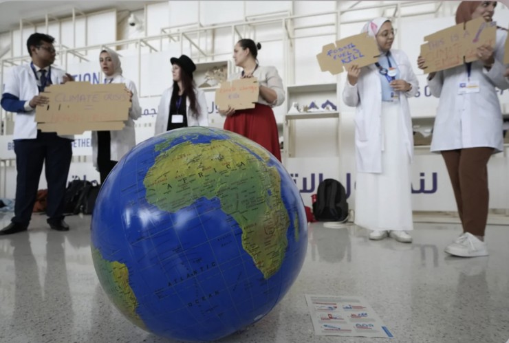 Một người phụ nữ giả vờ như đang hồi sinh Trái đất trong cuộc tuần hành tại Hội nghị thượng đỉnh về khí hậu của Liên hợp quốc COP28, Chúa nhật, ngày 3 tháng 12 năm 2023, tại Dubai, Các Tiểu vương quốc Ả Rập Thống nhất (Ảnh: Peter Dejong/AP)