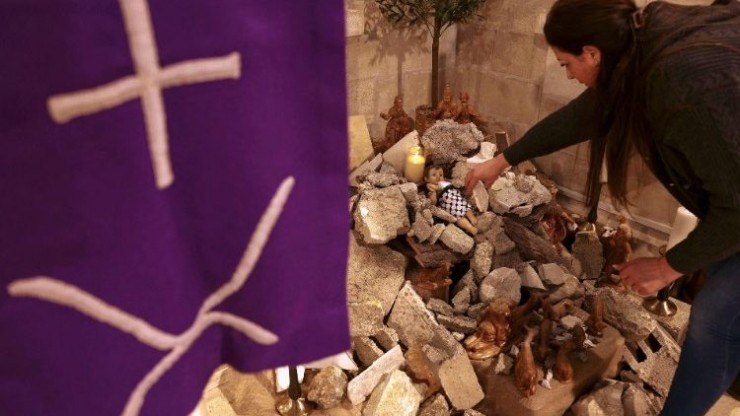 Một người phụ nữ đang làm hang đá Giáng sinh ở Bethlehem (Ảnh: AFP)