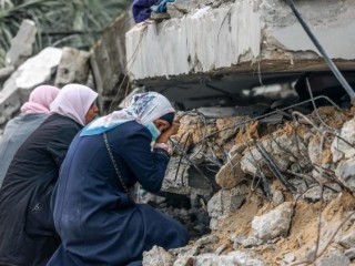 PMột số phụ nữ Palestine đang than khóc tại nơi người thân được cho là bị mắc kẹt trong đống đổ nát sau vụ ném bom của Israel ở Rafah, phía nam Dải Gaza (Ảnh: AFP)