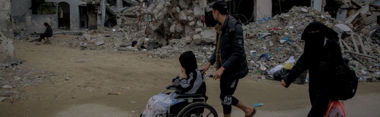 Mọi người đi ngang qua ngôi nhà bị phá hủy ở Jabaliya, phía bắc Gaza (Ảnh: UNICEF/Al-Qattaa, ngày 7 tháng 12 năm 2023)