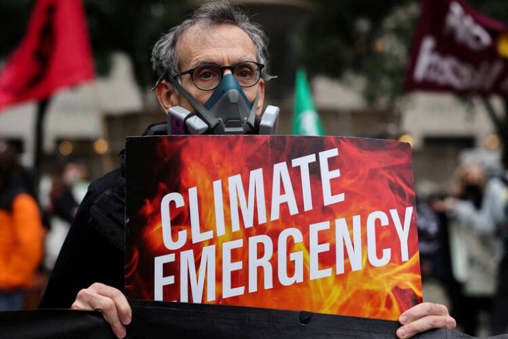 Một nhà hoạt động khí hậu đeo mặt nạ bảo vệ biểu tình vào ngày 8 tháng 6 năm 2023, trong khi khói và sương mù do cháy rừng ở Canada đi qua Thành phố New York. (Ảnh: OSV News/Amr Alfiky, Reuters)