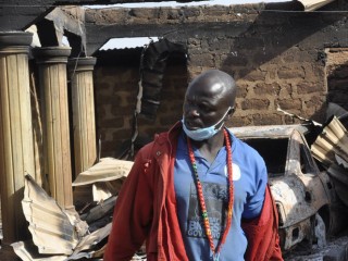 Một người đàn ông đứng trước ngôi nhà bị thiêu rụi sau vụ tấn công của các tay súng ở Bokkos, miền trung bắc Nigeria, vào ngày 26/12/2023 (Ảnh: AP)