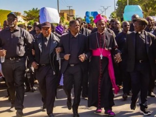 Đức Tổng Giám mục Công giáo Matthew Ishaya Audu Địa phận Jos diễu hành cùng với nhà lãnh đạo truyền giáo, Tiến sĩ Gideon Para-Mallam, trước tòa nhà văn phòng thống đốc bang Plateau ở Jos, Nigeria, ngày 8 tháng 1 năm 2024 (Ảnh do Tiến sĩ Gideon Para-Mallam cung cấp, ảnh của Nhóm Truyền thông Chính quyền Bang Plateau)