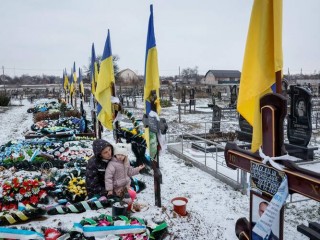 Alona Onyshchuk, 39 tuổi, đến thăm mộ chồng cùng con gái, Anhelina, 5 tuổi, tại Hẻm Anh hùng tại một nghĩa trang địa phương ở làng Lozuvatka, vùng Dnipropetrovsk, Ukraine, ngày 22 tháng 1 năm 2024, trong bối cảnh Nga tấn công Ukraine (Ảnh: OSV News/Alina Smutko, Reuters)