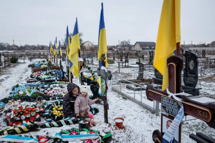Alona Onyshchuk, 39 tuổi, đến thăm mộ chồng cùng con gái, Anhelina, 5 tuổi, tại Hẻm Anh hùng tại một nghĩa trang địa phương ở làng Lozuvatka, vùng Dnipropetrovsk, Ukraine, ngày 22 tháng 1 năm 2024, trong bối cảnh Nga tấn công Ukraine (Ảnh: OSV News/Alina Smutko, Reuters)