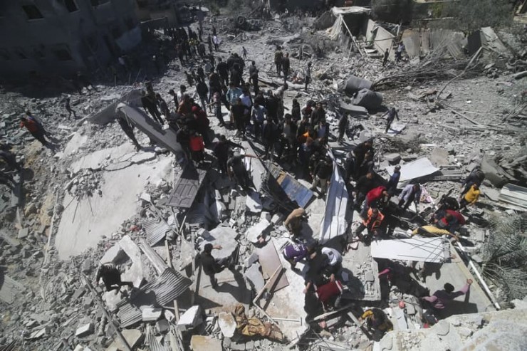 Người dân Palestine nhìn một tòa nhà dân cư bị lực lượng Israel phá hủy ở Rafah, Gaza, vào ngày 20 tháng 3 năm 2024 (Ảnh: Hatem Ali/AP)
