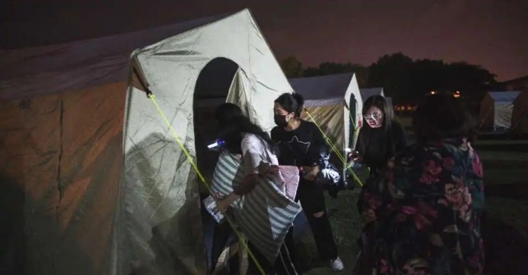 Những người bị ảnh hưởng bởi trận động đất bước vào lều tại trung tâm tiếp nhận tạm thời được dựng tại một trường học địa phương ở Hoa Liên vào ngày 3 tháng 4 năm 2024, sau khi một trận động đất lớn xảy ra ở phía đông Đài Loan. Ít nhất 10 người thiệt mạng và hơn 1.000 người bị thương hôm 3/4 do trận động đất mạnh làm hư hại hàng chục tòa nhà (Ảnh: AFP)
