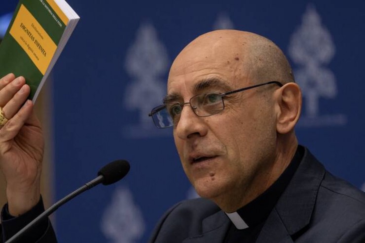 Đức Hồng Y Víctor Manuel Fernández,  Tổng Trưởng Bộ Giáo lý Đức tin, giơ một bản sao tuyên bố của Bộ, “Dignitas Infinita,” trong cuộc họp báo tại văn phòng báo chí Vatican vào ngày 8 tháng 4 năm 2024 (Ảnh: CNS/Pablo Esparza)