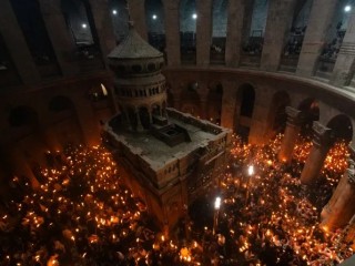 Những người hành hương cầm trên tay những ngọn nến được thắp sáng từ “Lửa Thánh” bên trong Vương cung Thánh đường Mộ Thánh ở Giêrusalem vào ngày 4 tháng 5 năm 2024 (Ảnh: Marinella Bandini/CNA)