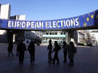 Một nhóm đứng dưới biểu ngữ của cuộc bầu cử bên ngoài Nghị viện Châu Âu ở Brussels vào ngày 29 tháng 4 năm 2024 (Ảnh: Virginia Mayo/AP)