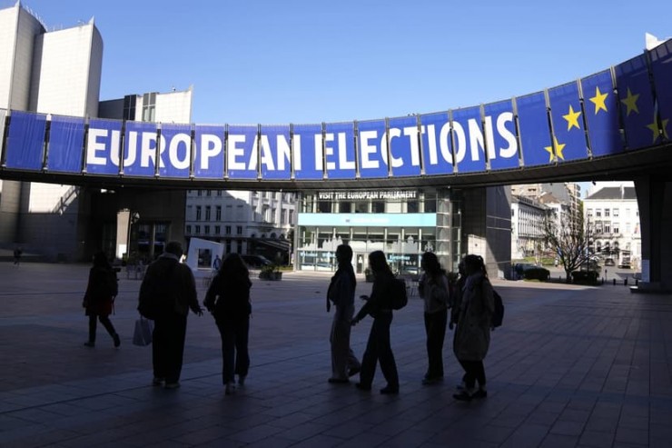 Một nhóm đứng dưới biểu ngữ của cuộc bầu cử bên ngoài Nghị viện Châu Âu ở Brussels vào ngày 29 tháng 4 năm 2024 (Ảnh: Virginia Mayo/AP)