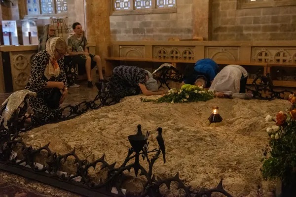 Một nhóm nhỏ các Kitô hữu Chính thống từ Romania bên trong Vương cung Thánh đường Gethsemane hôn tảng đá mà theo truyền thống, Chúa Giêsu đã đổ mồ hôi máu trong đêm Thứ Năm Tuần Thánh. tháng 5 năm 2024 (Ảnh: Marinella Bandini)