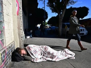 Một người đàn ông vô gia cư ngủ trên vỉa hè ở trung tâm thành phố Los Angeles vào ngày 22 tháng 11 năm 2023 (Ảnh: FREDERIC J. BROWN/AFP via Getty Images)