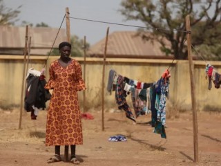 Một phụ nữ Kitô giáo đứng cạnh dây phơi quần áo khi trú ẩn trong trại tập trung dành cho những người di tản trong nước (IDP) tại Trường Tiểu học Thí điểm sau khi nhà của họ bị phóng hỏa do xung đột tôn giáo ở Mangu vào ngày 2 tháng 2 năm 2024, sau nhiều tuần bạo lực giữa các cộng đồng và tình trạng bất ổn ở bang Plateau (Ảnh: KOLA SULAIMON/AFP via Getty Images)