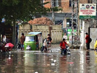 Người đi làm lội qua một con phố ngập nước sau trận mưa lớn ở Rawalpindi, Pakistan, vào ngày 20 tháng 9 năm 2021 (Ảnh: AFP)