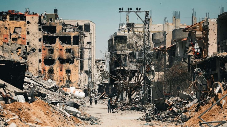 Người dân Palestine đi bộ giữa sự tàn phá của Gaza (Ảnh: MAJDY JILDAH)
