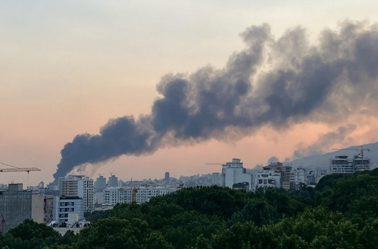 Khói bốc lên từ vụ tấn công vào tòa nhà phát sóng của Iran trên bầu trời Tehran (Ảnh Vatican News)