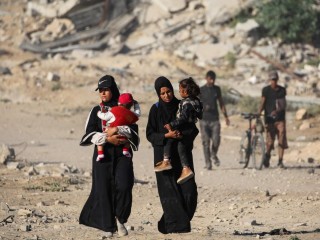 Phụ nữ Palestine bế con trên đường đến Thành phố Gaza (Ảnh: AFP)