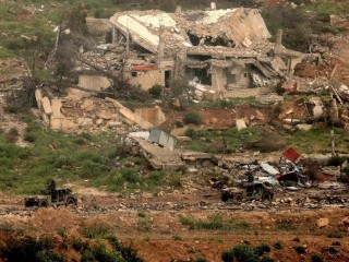 Các phương tiện quân sự của Israel di chuyển qua những tòa nhà bị phá hủy ở miền nam Lebanon, gần biên giới Israel vào ngày 26 tháng 3 (Ảnh: AFP)