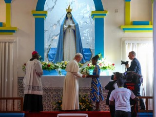 Đức Thánh Cha Lêô XIV đặt hoa dưới chân tượng Đức Mẹ Maria trong Đền thánh Đức Mẹ Muxima, vào ngày thứ bảy trong chuyến tông du 11 ngày đến châu Phi, tại Muxima, Angola, Chủ nhật, ngày 19 tháng 4 năm 2026 (Ảnh: Guglielmo Mangiapane/Pool Photo via AP)