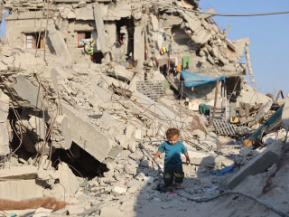 Một trẻ em Palestine đi ngang qua đống đổ nát của các tòa nhà bị phá hủy tại trại tị nạn Jabalia ở phía bắc Dải Gaza vào ngày 2 tháng 8 năm 2026 (Ảnh: Omar AL-QATTAA/AFP/  Getty Images)